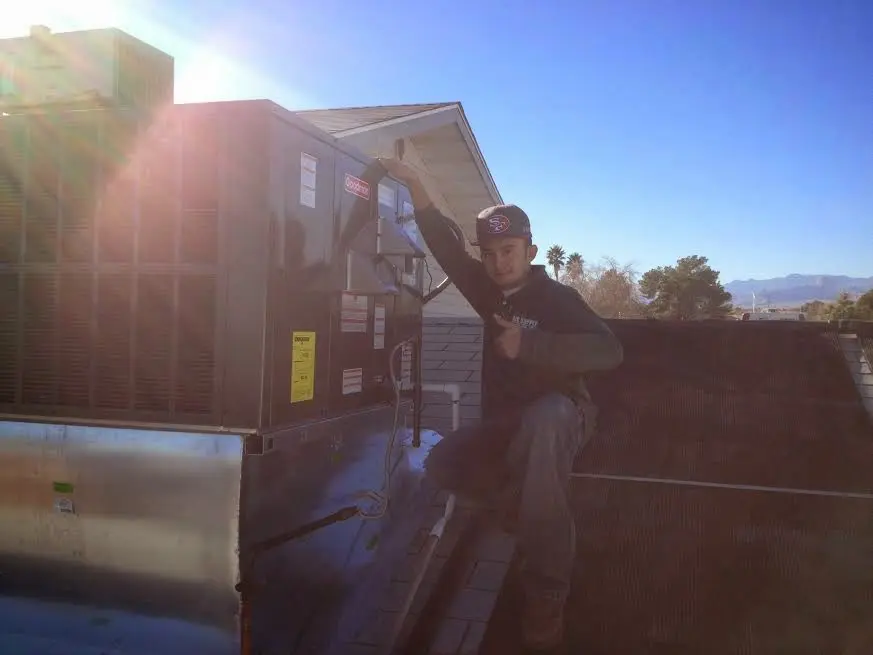 HVAC technician performing Boiler Repair on a rooftop unit in Aurora
